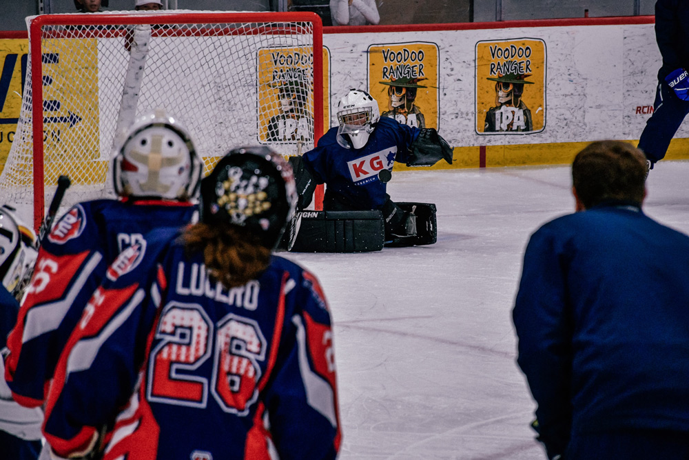 Campers listening to coaching instruction on the ice