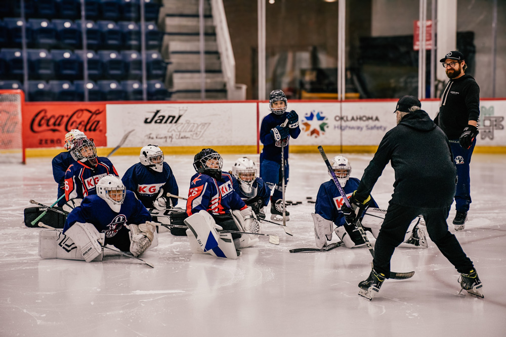 Coach giving feedback to a goalie between reps